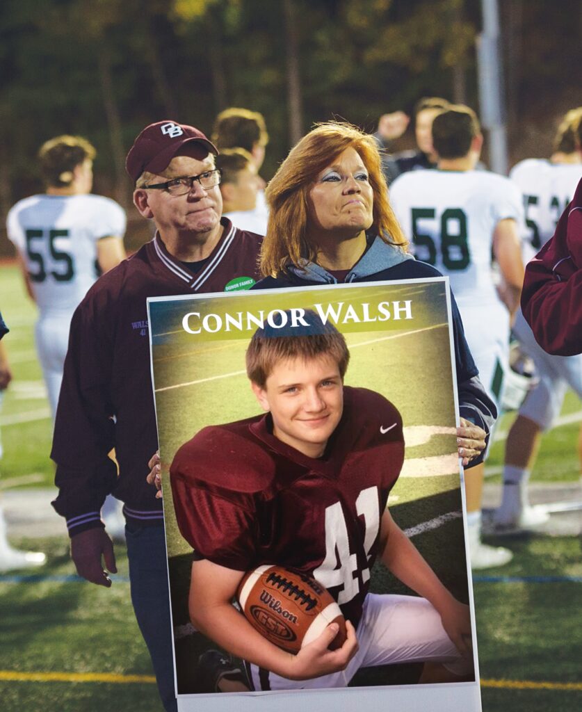 Photo of Bill and Alice Walsh holding a poster of Connor Walsh.